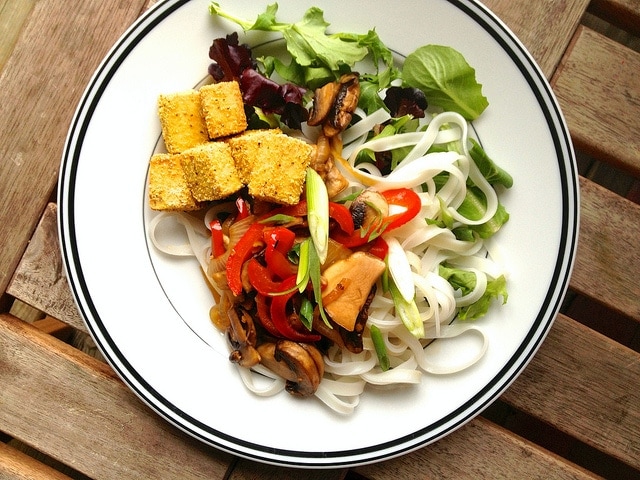 crispy salt and pepper tofu on a plate with rice noodles