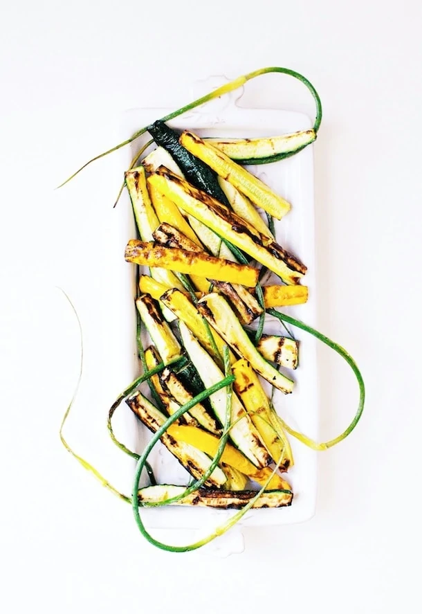 Grilled Summer Squash & Garlic Scapes on a white plate