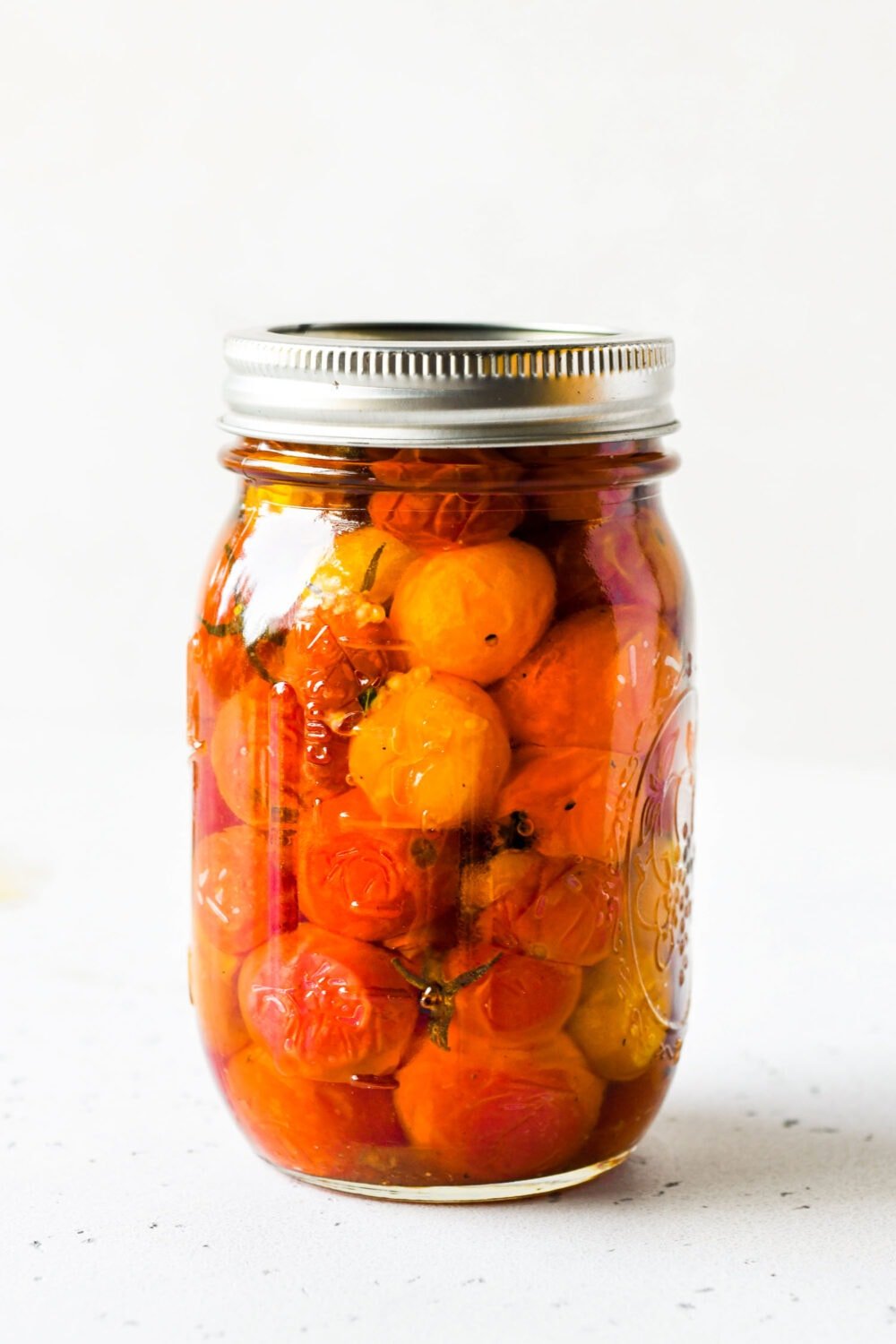 cherry tomatoes preserved in olive oil in a ball jar