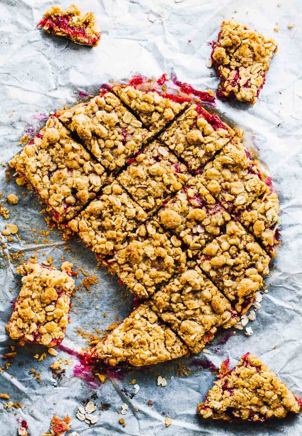 gluten-free rhubarb crumble bars cut into squares, on parchment paper