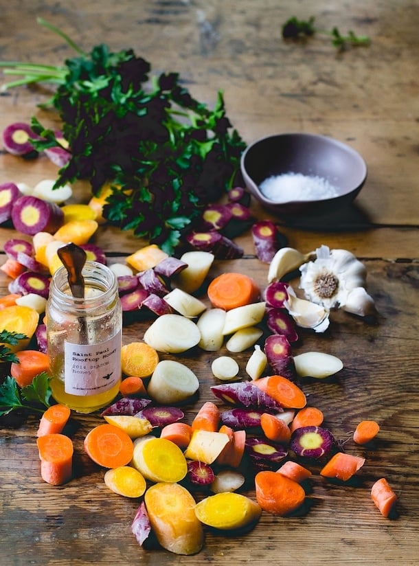 rainbow carrots cut into slices, with garlic clove in backround. 