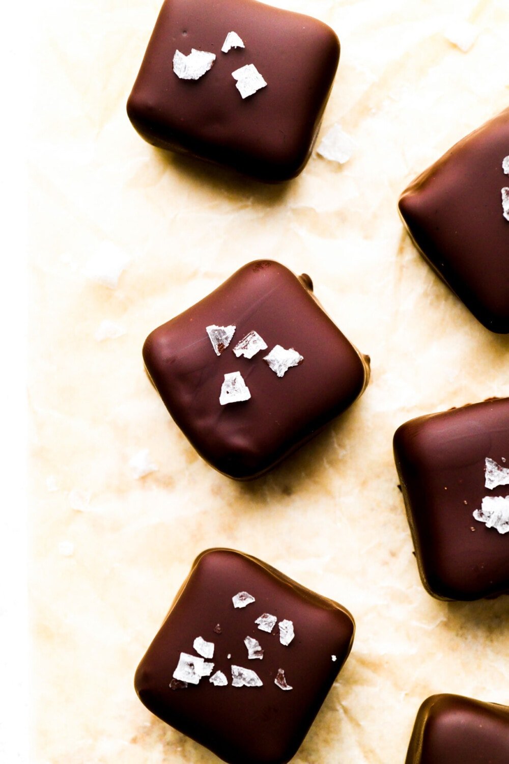 chocolate caramels with sea salt on parchment paper.