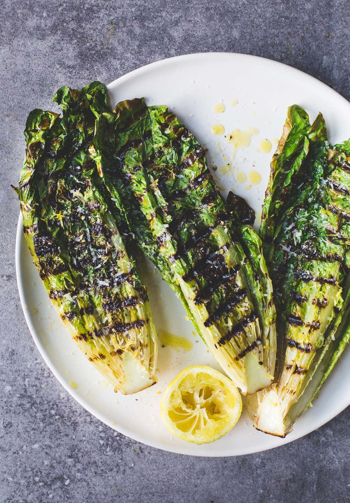 Simple Italian Grilled Romaine Lettuce Salad on a plate with half lemon