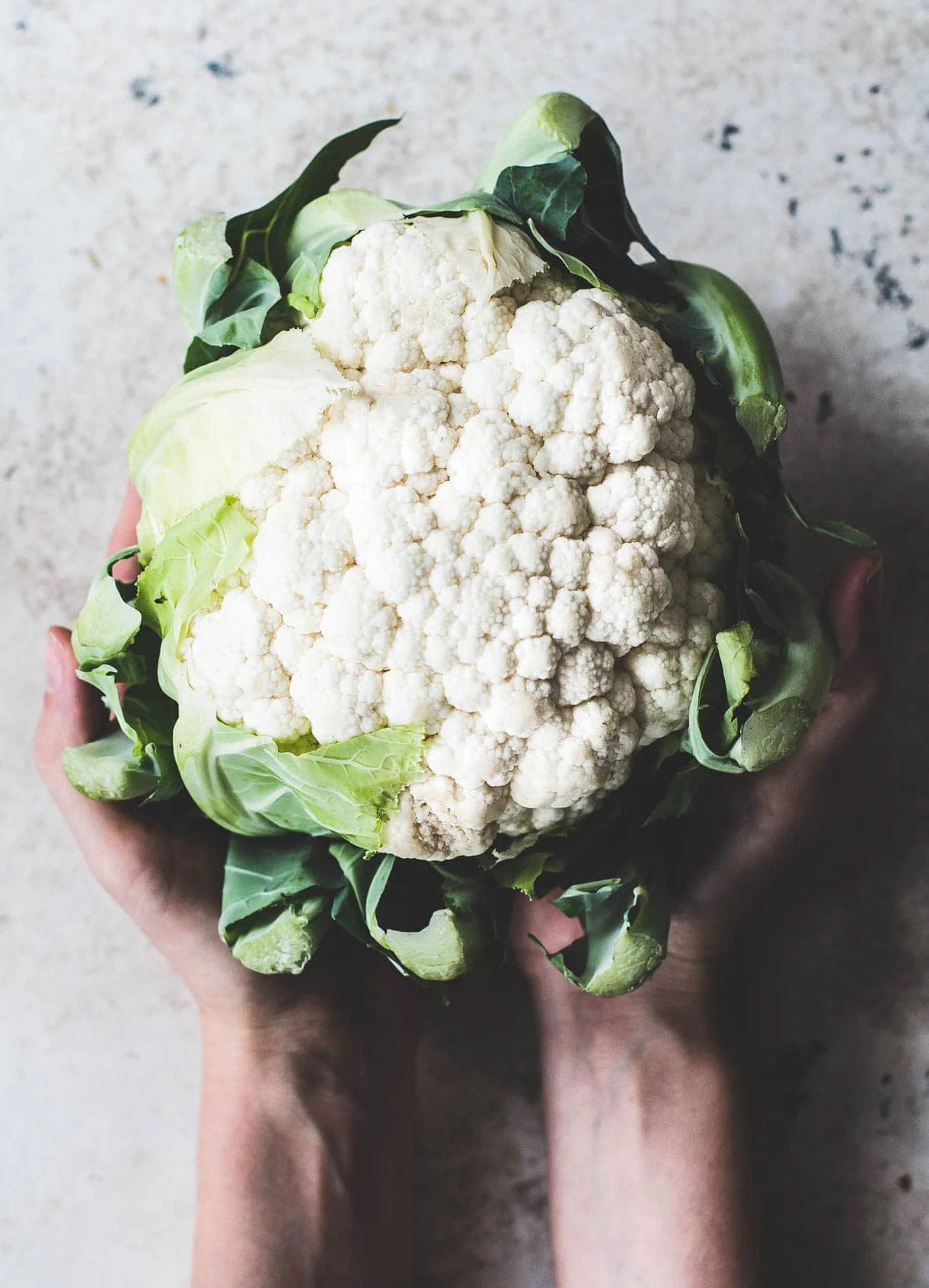 a head of cauliflower in hands, #foodstyling