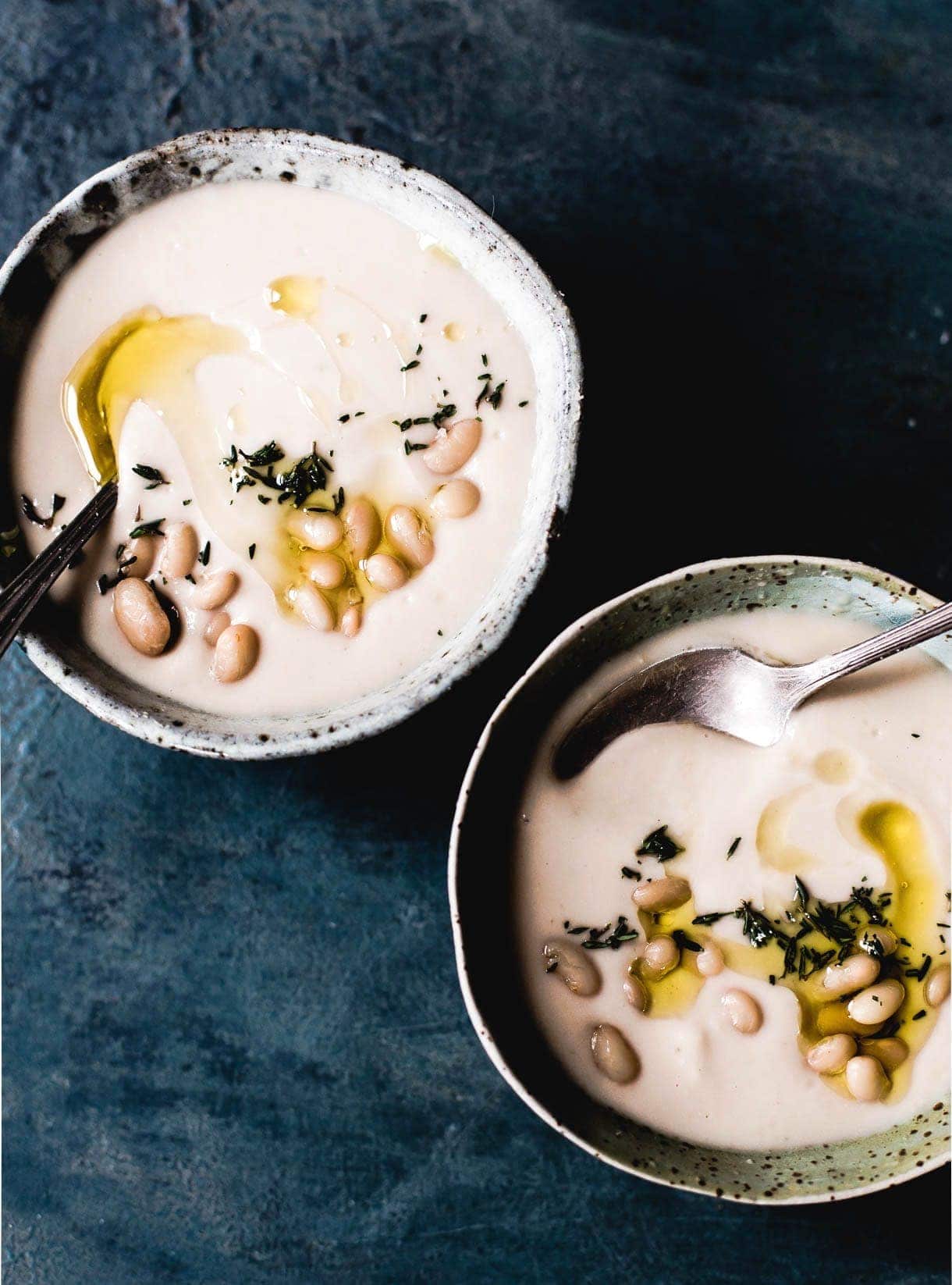 two bowls of white bean soup made in an instant pot sitting by side