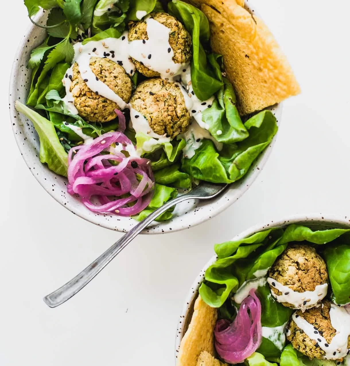 two bowls of baked falafel salad, overhead view.