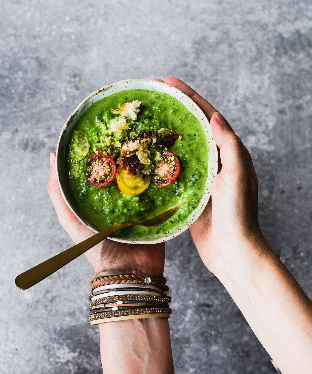 holding a bowl of broccoli potato cheese soup