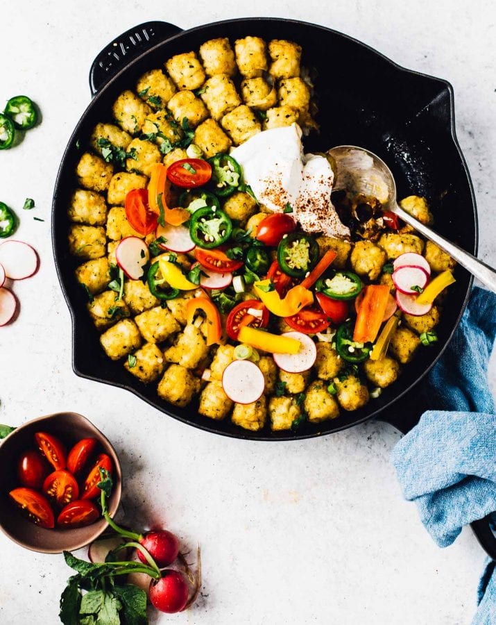 spoonful removed from taco tater tot hotdish in a cast iron skillet