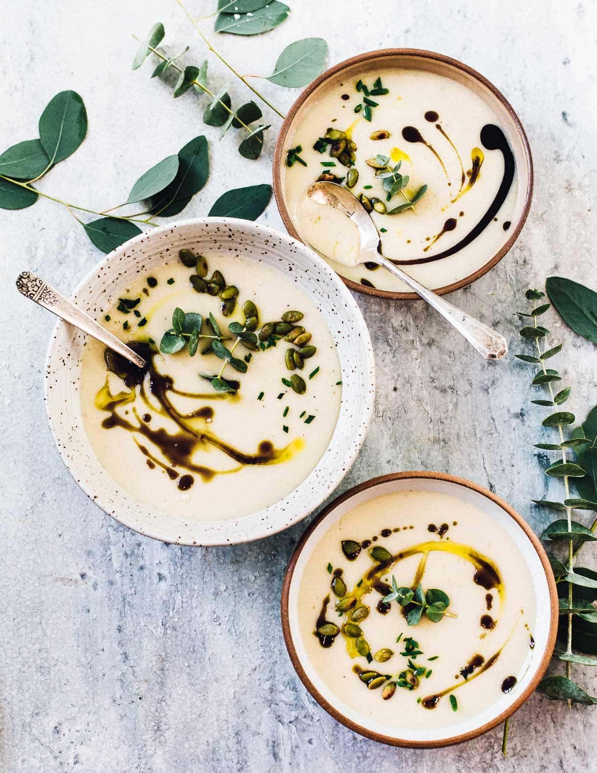 Dairy Free Parsnip Potato Soup in bowls with pumpkin seed oil
