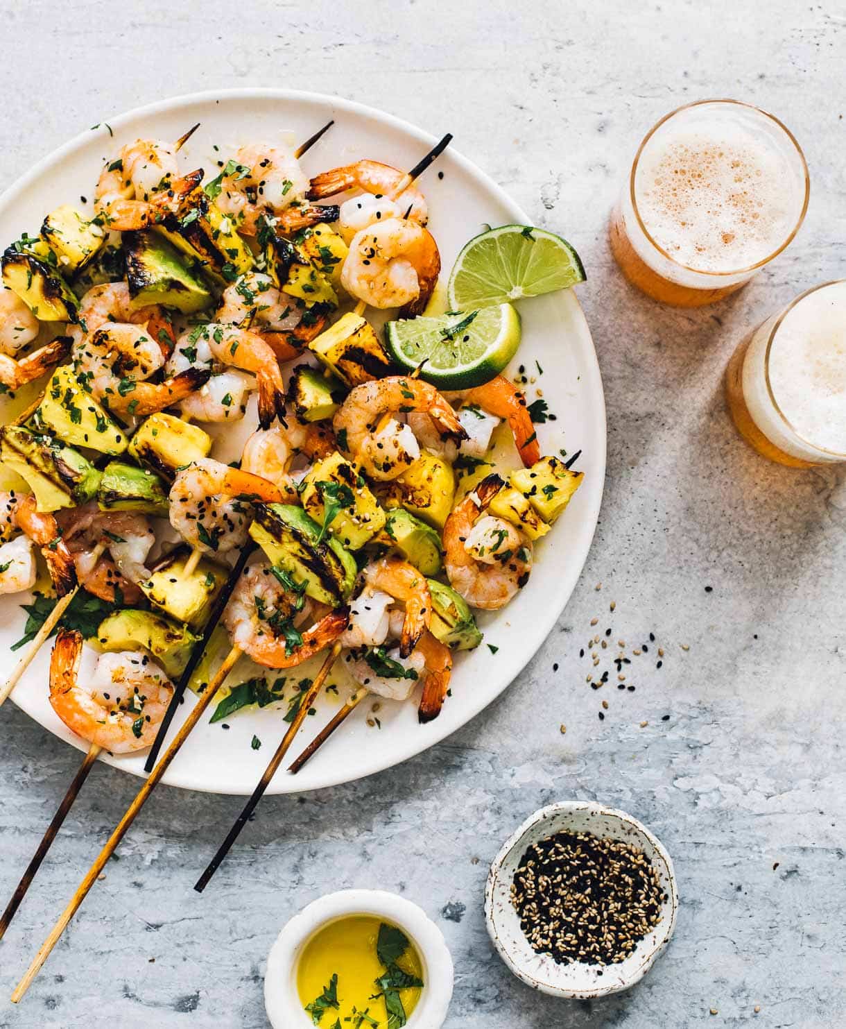 grilled shrimp skewer with pineapple and avocado served with beer