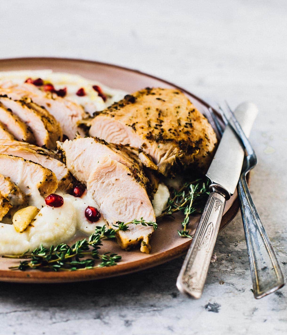 sliced turkey breast tenderloin on bed of cauliflower mash, plated with silverware