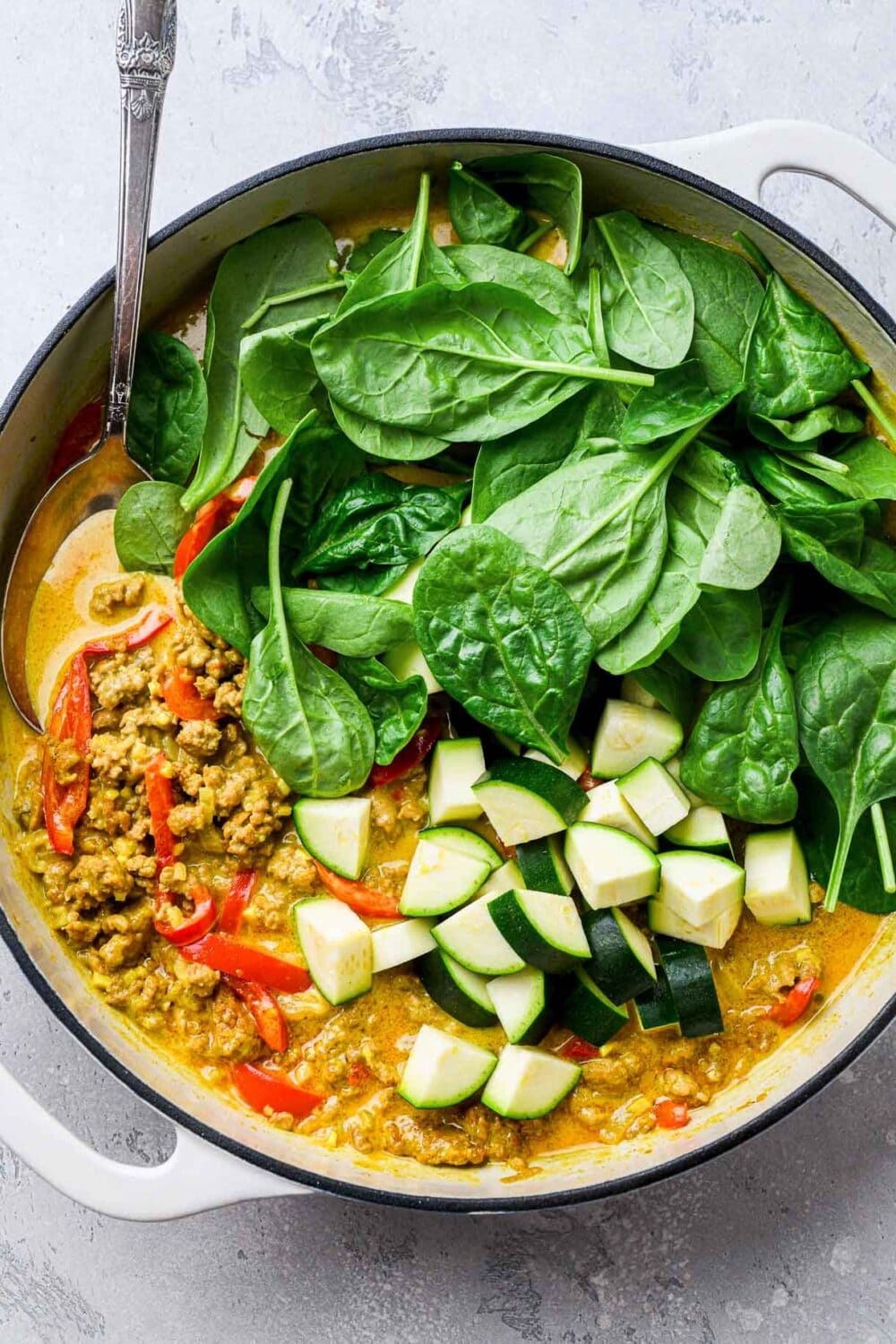 veggies and coconut turkey curry in a braising pot