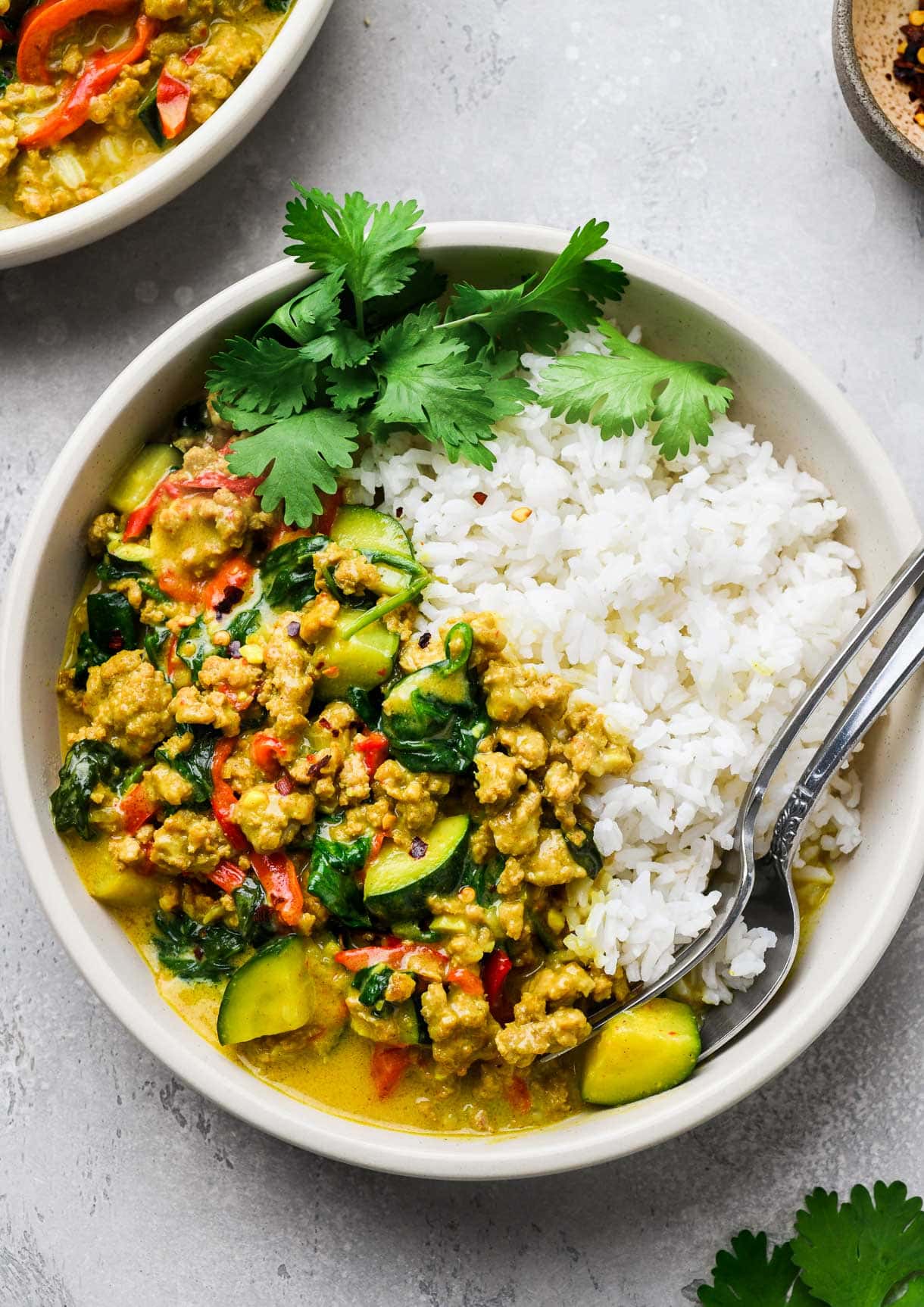 ground turkey curry in a bowl with white rice, two spoons