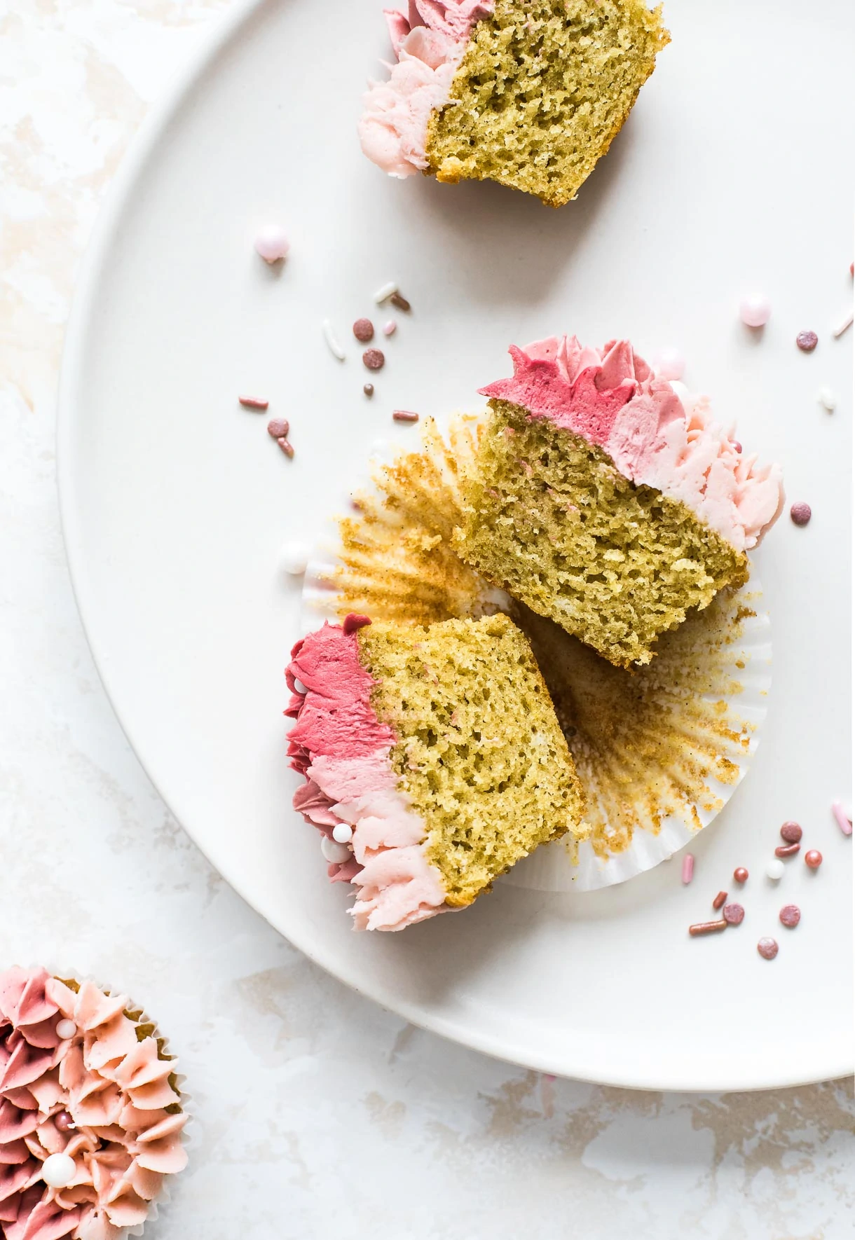 gluten free vanilla cupcakes cut open to show crumb, with pink rose sprinkles