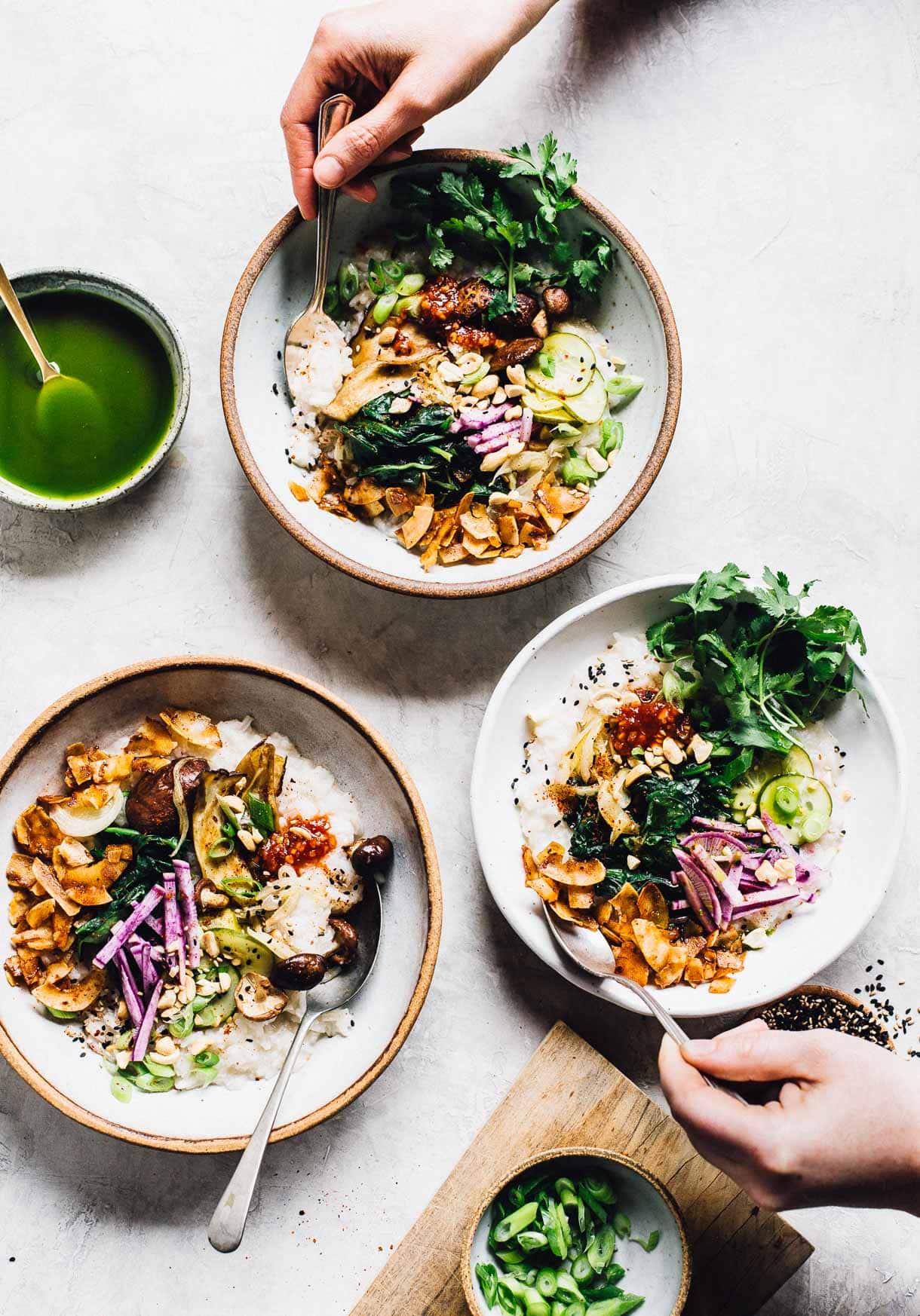 three bowls of instant pot congee, with  people's hand in the photo