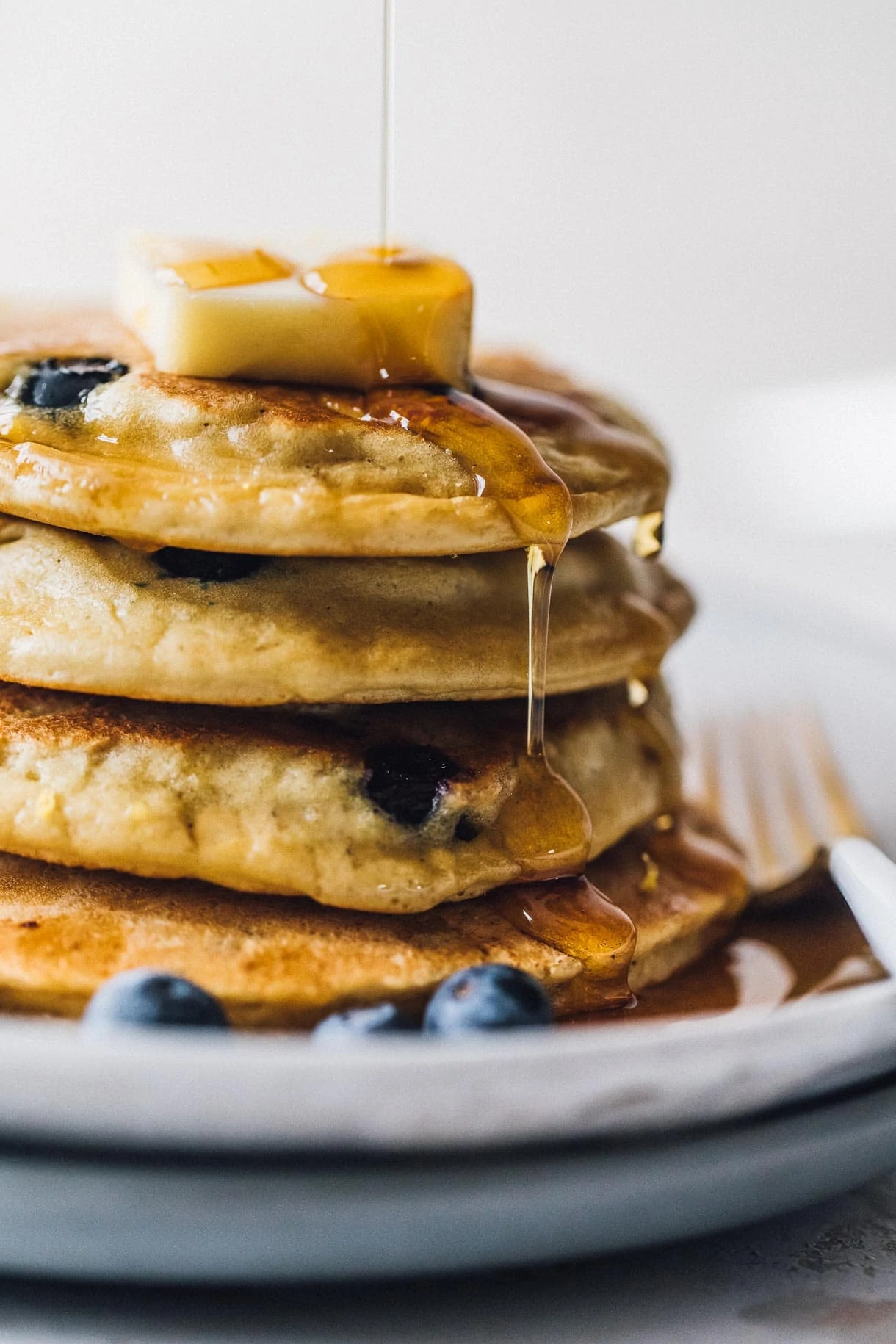 blueberry pancakes dripping with maple syrup