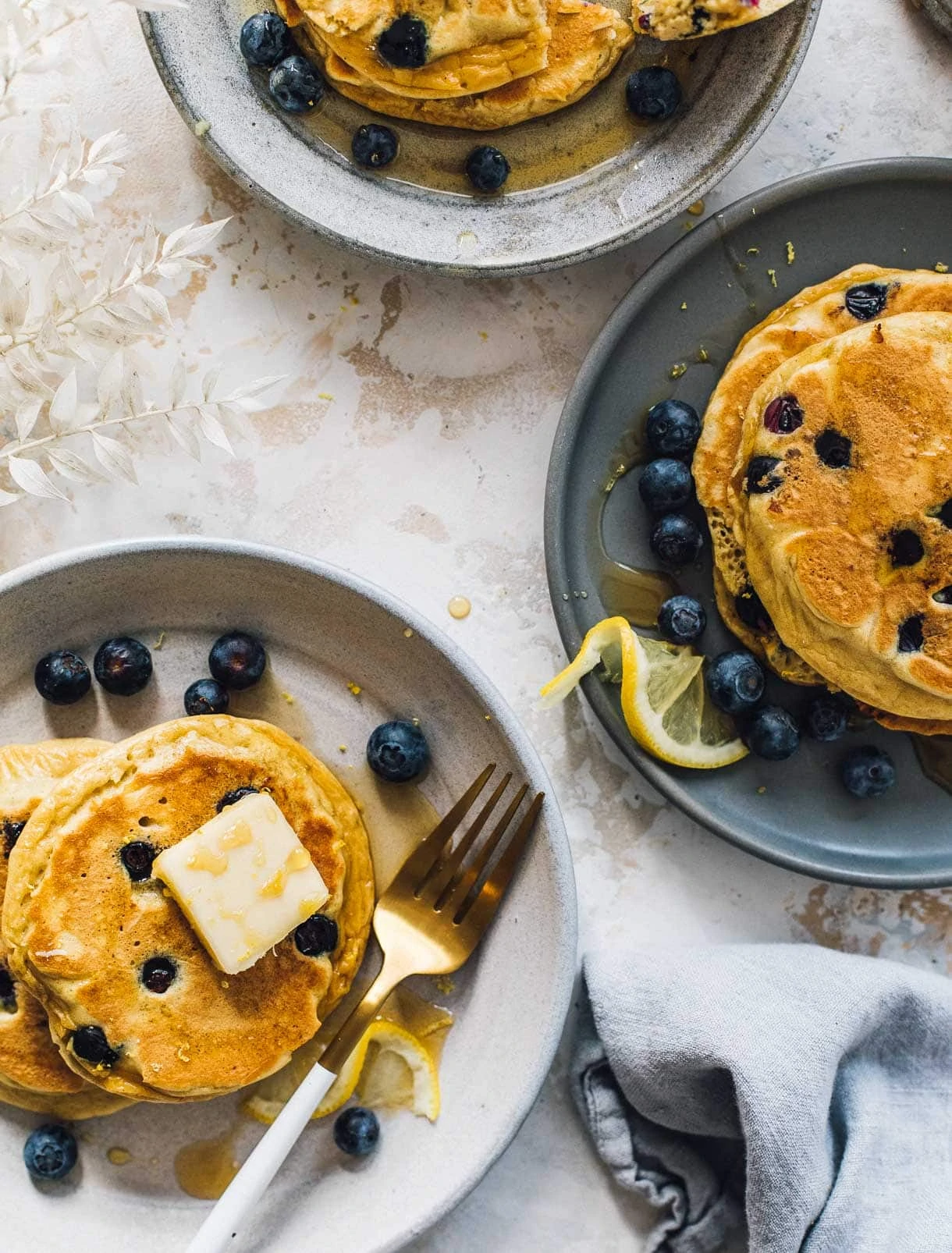 three plates with blueberry pancakes