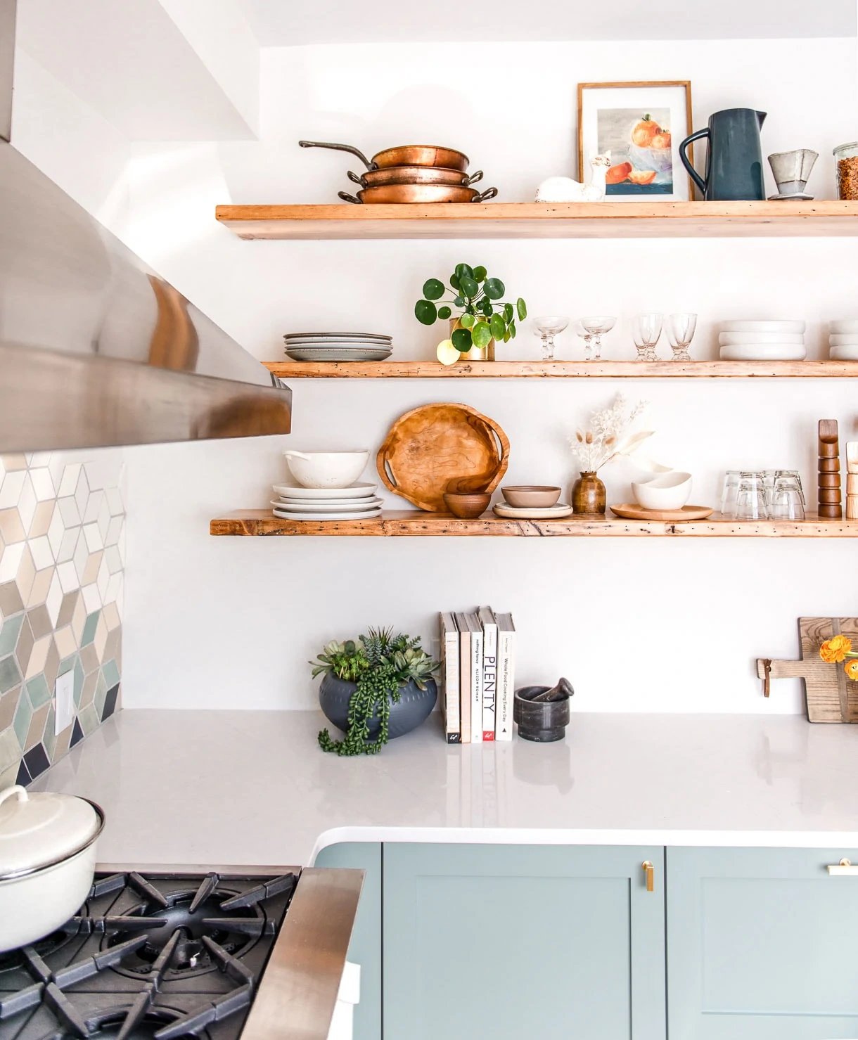 open shelving with ceramics, cookbooks in kitchen, copper cookware