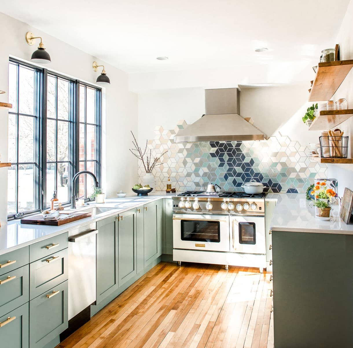 white kitchen with frameless window and sage green cabinets