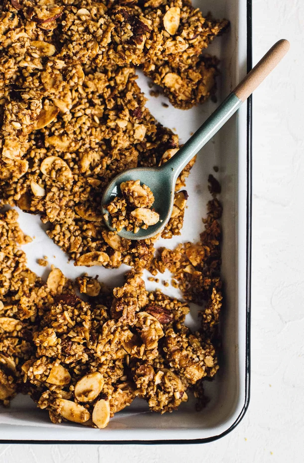 clumpy granola in a pan with a spoon