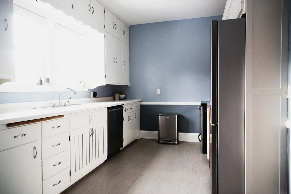 u-shaped kitchen with blue walls and white cupboards