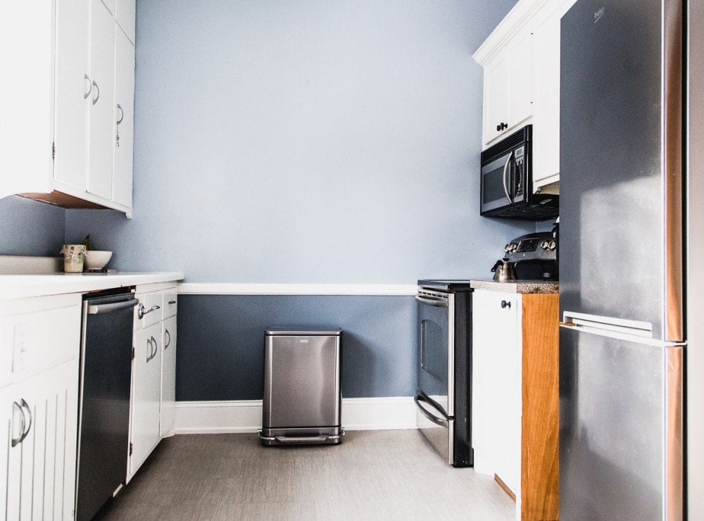 u-shaped kitchen with blue walls and white cupboards