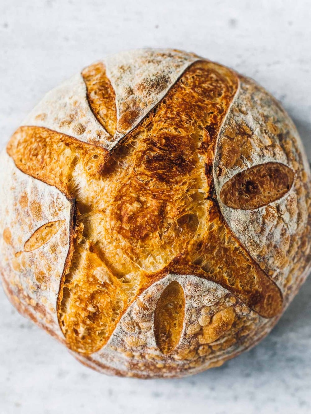 loaf of sourdough bread with pretty score, top down view