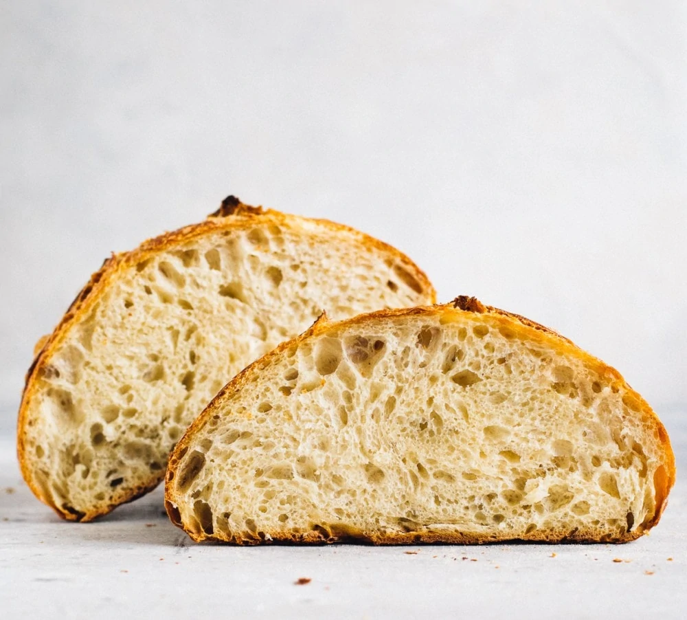 open crumb shot of sourdough bread loaf, cut in half