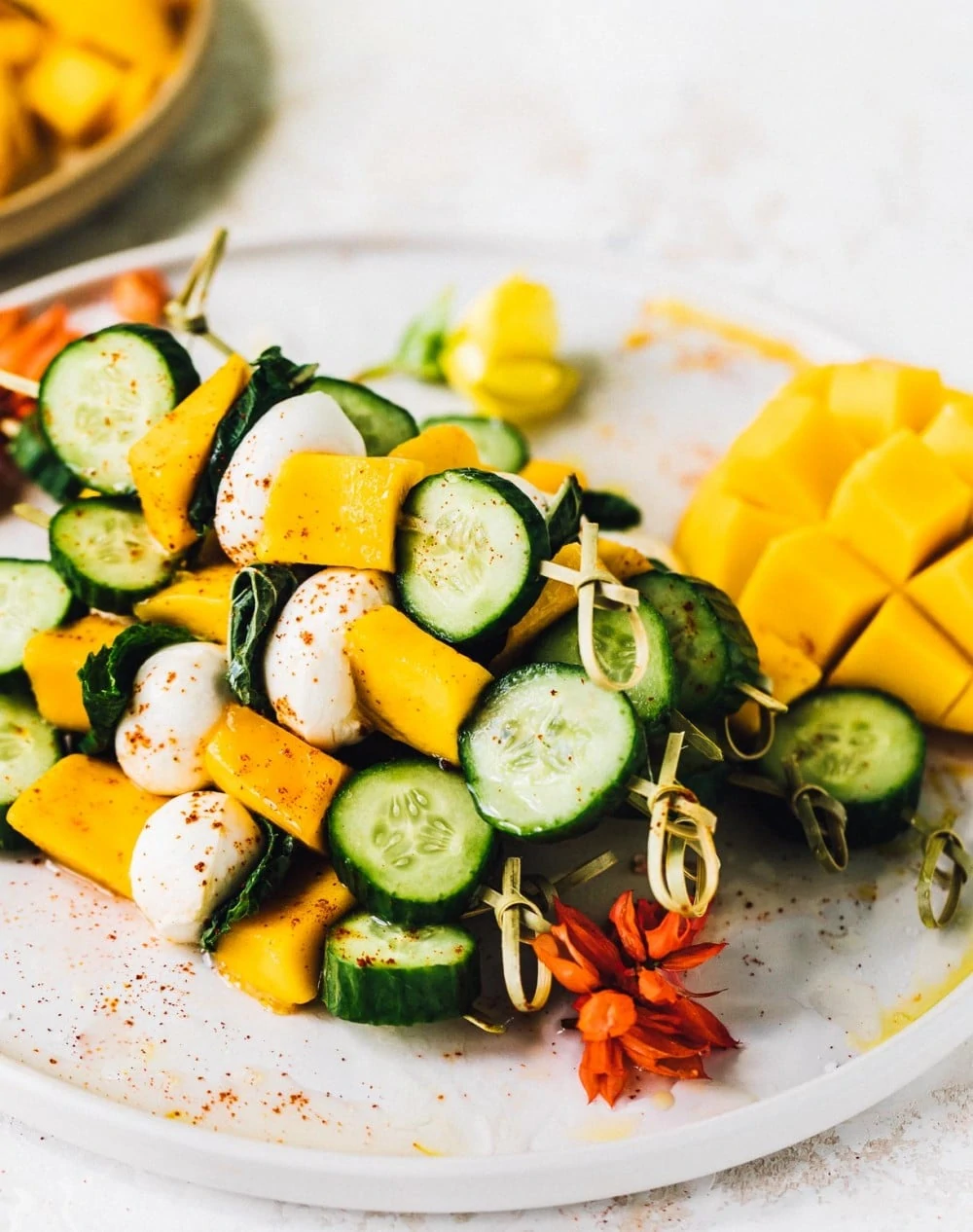 mango mozzarella skewers stacked on a plate