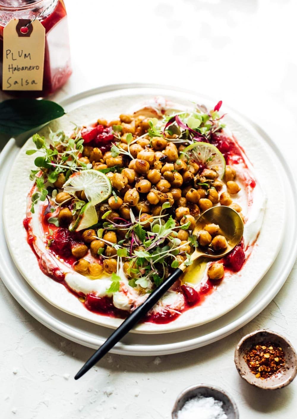 frizzled chickpeas on a plate with sour cream and plum salsa