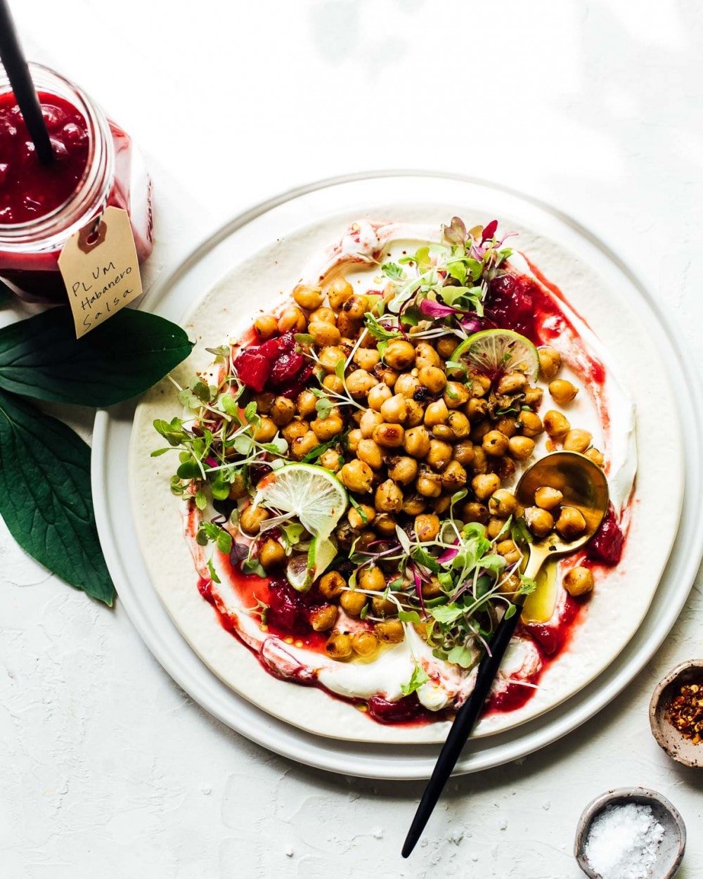 frizzled chickpeas on a plate with sour cream and plum salsa