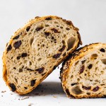 tart cherry sourdough bread, a loaf cut in half and showing the interior crumb