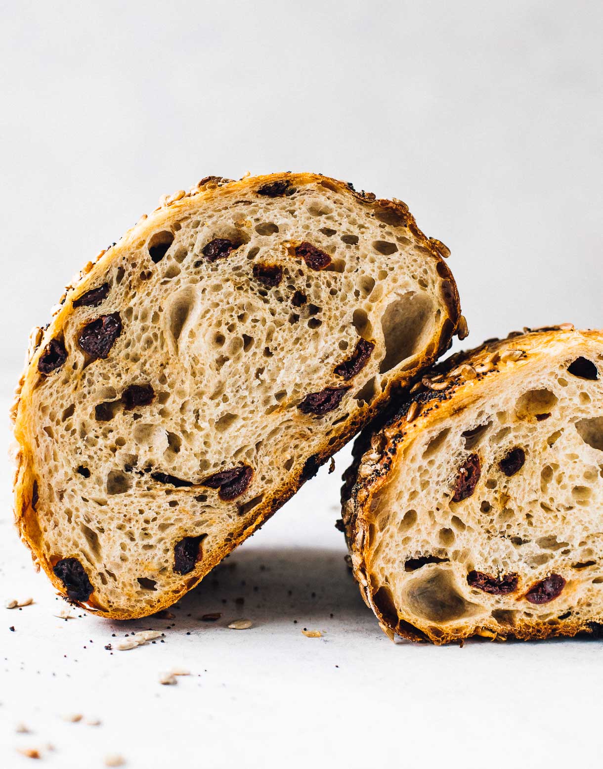 tart cherry sourdough bread, a loaf cut in half and showing the interior crumb