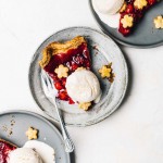 a slice of cherry pie with vanilla ice cream, on 3 plates, overhead photo