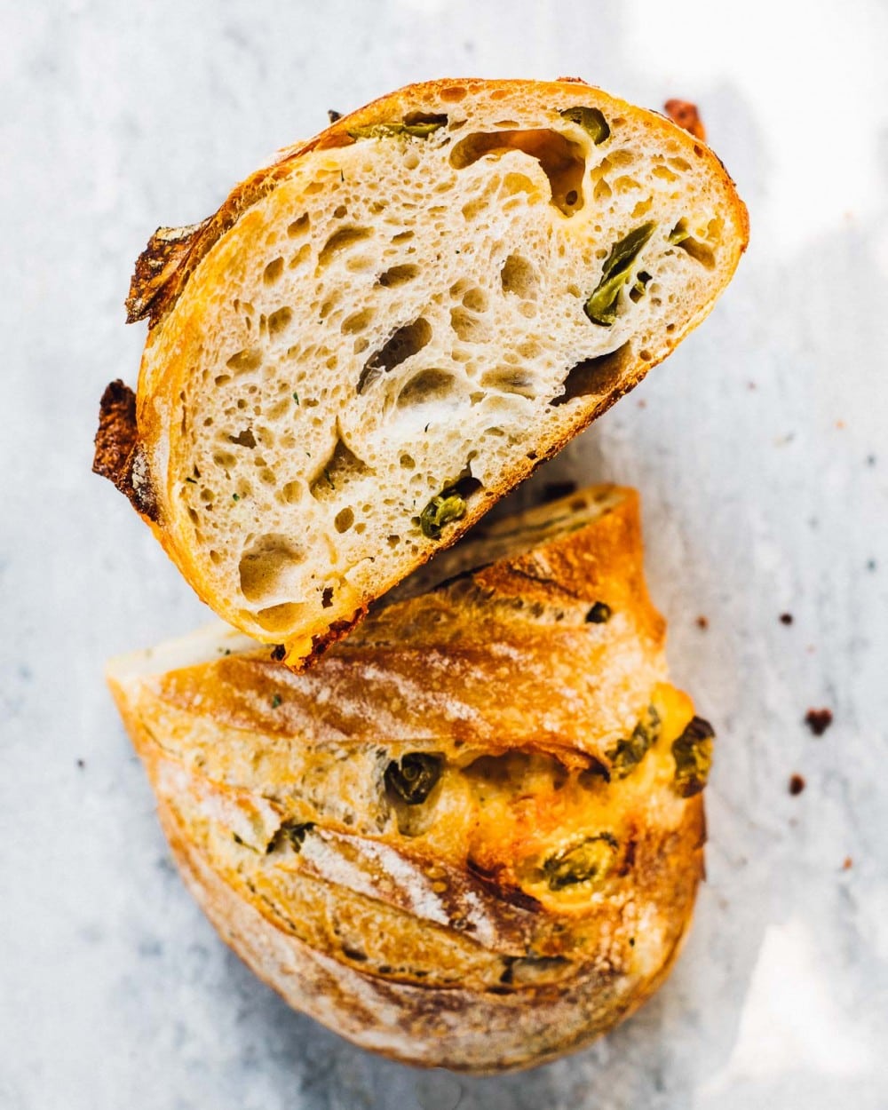 jalapeno sourdough cheese bread, cut in half with crumb showing