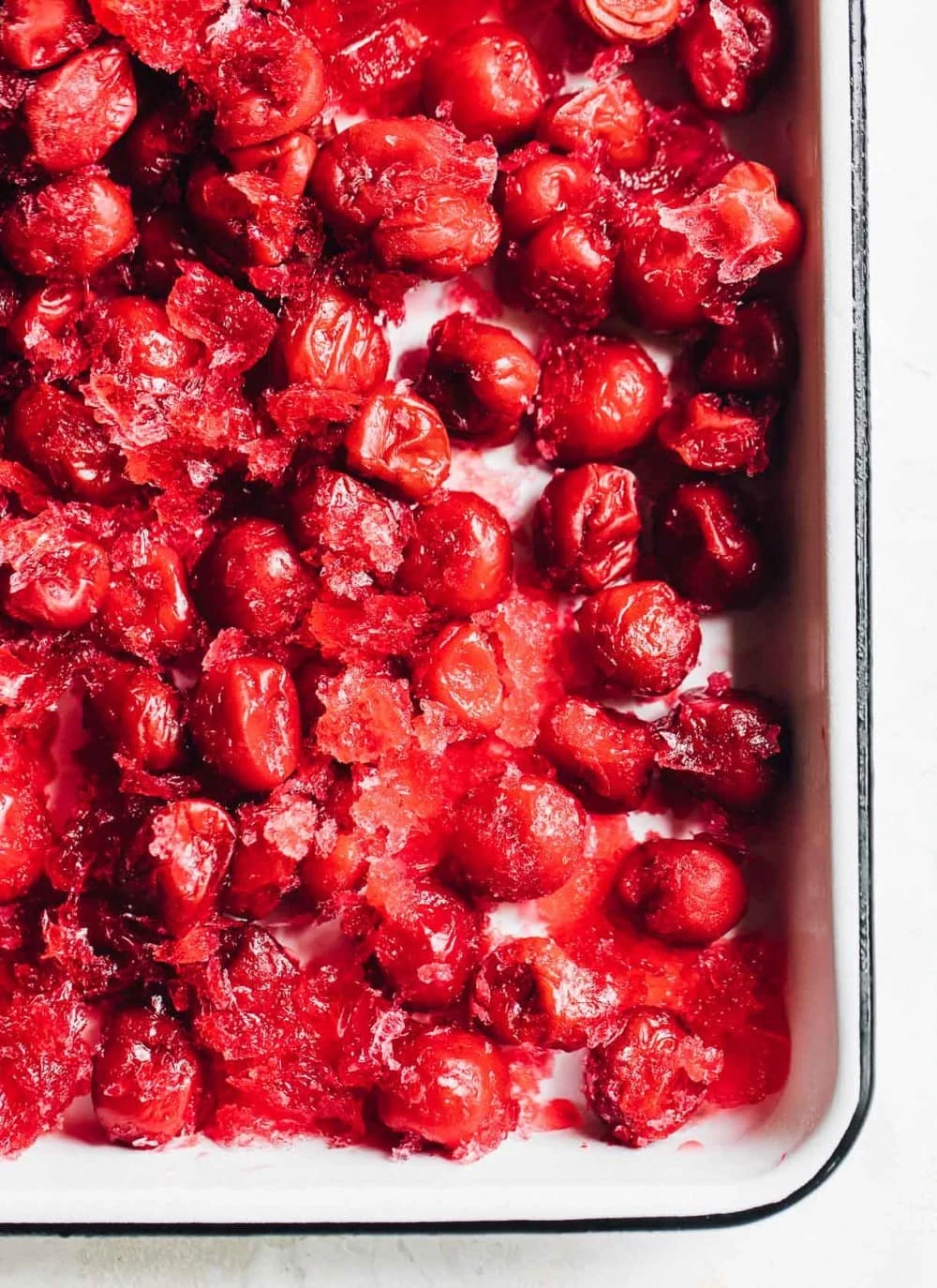 frozen tart cherries in a white enamel pan