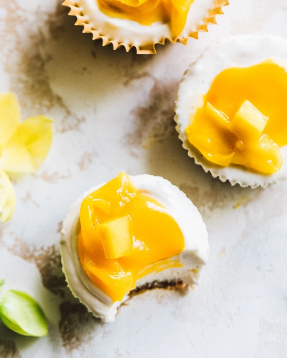 no-bake mango cheesecake bites, one with bite taken out of it