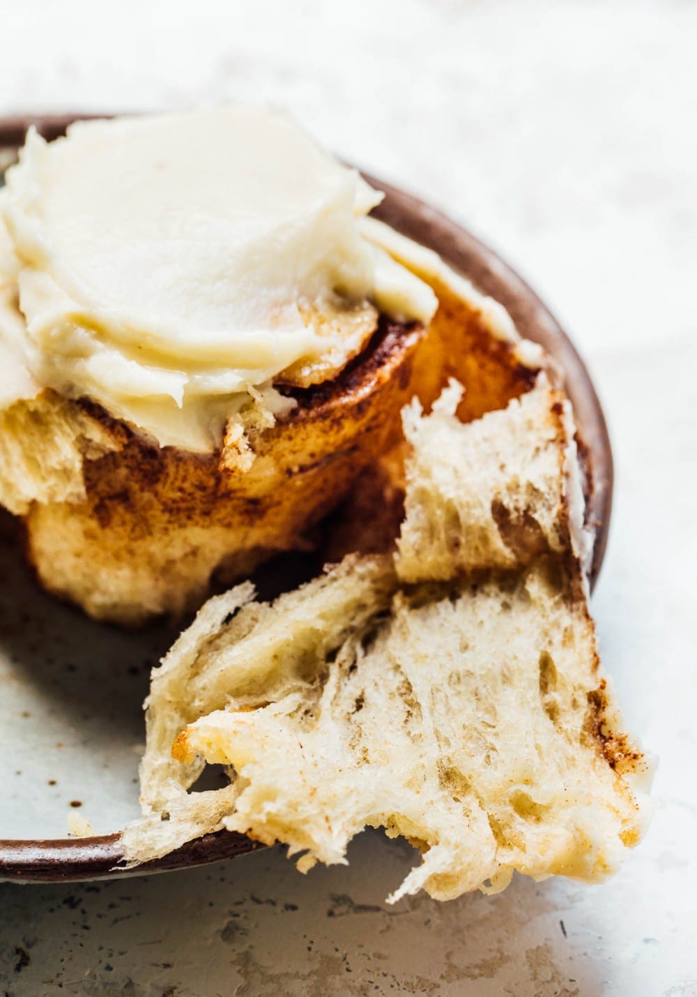 cinnamon roll with cream cheese frosting on a blue plate