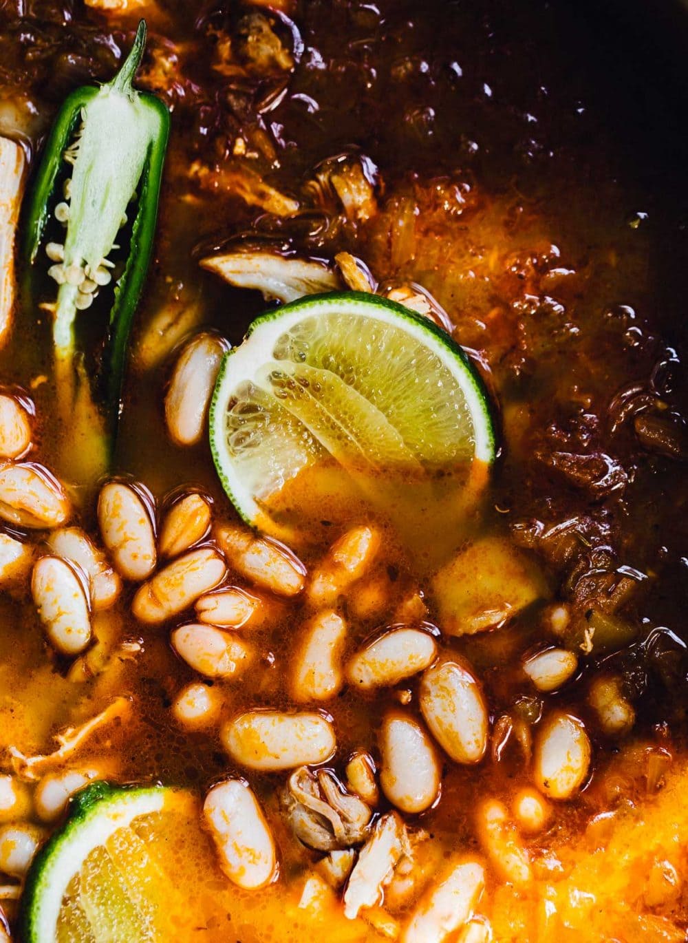 brothy chicken chili with white beans, lime in soup, and jalapenos