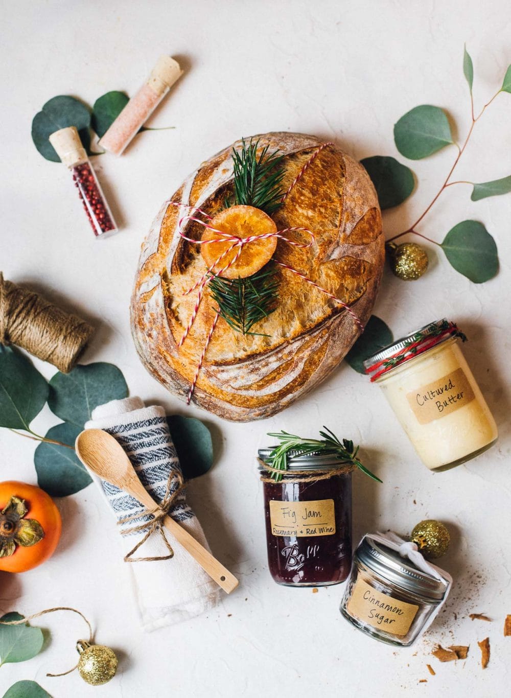 sourdough bread with kitchen linen next to it, jam, butter, cinnamon sugar in jars