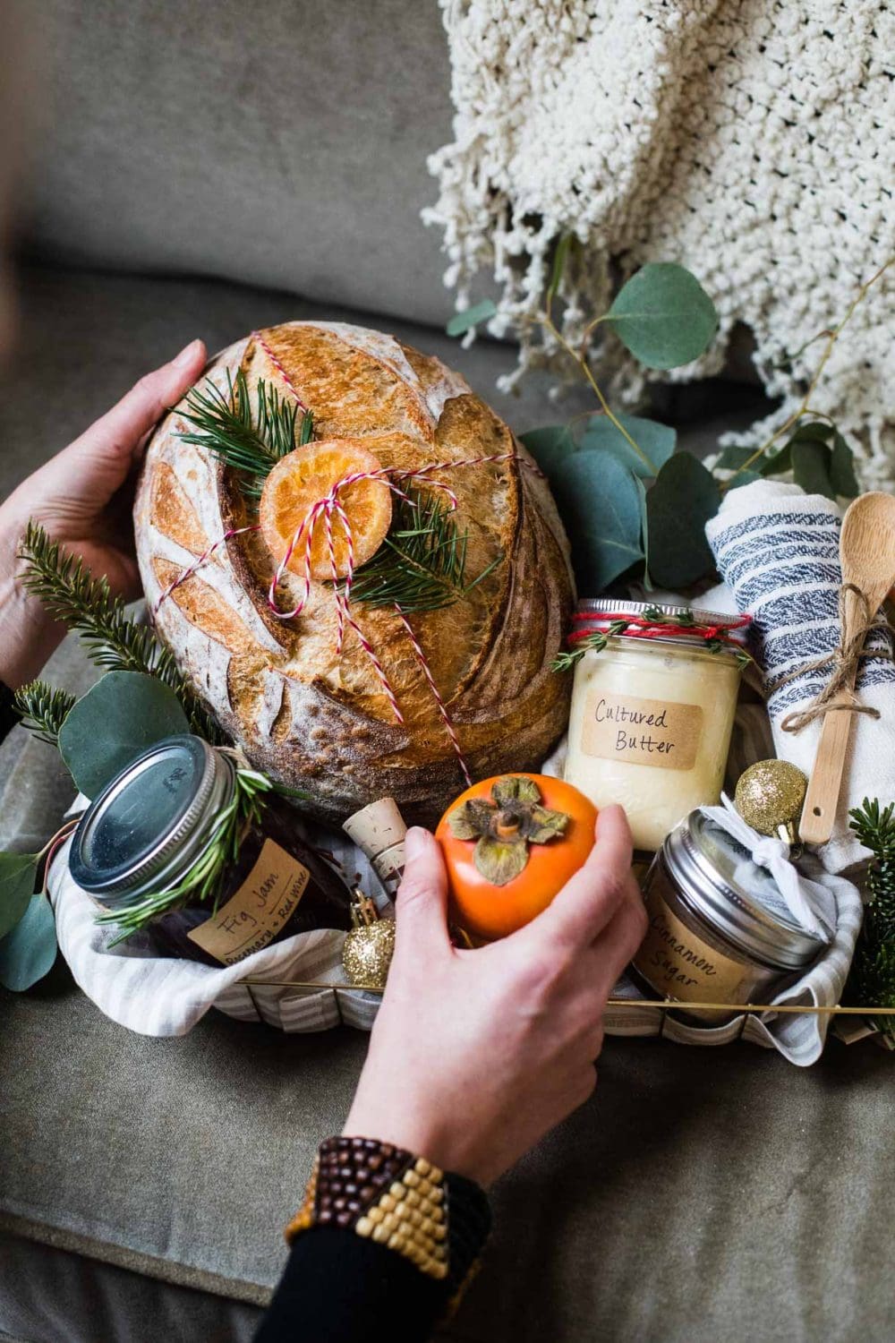 girl putting a loaf of bread into a gift basket