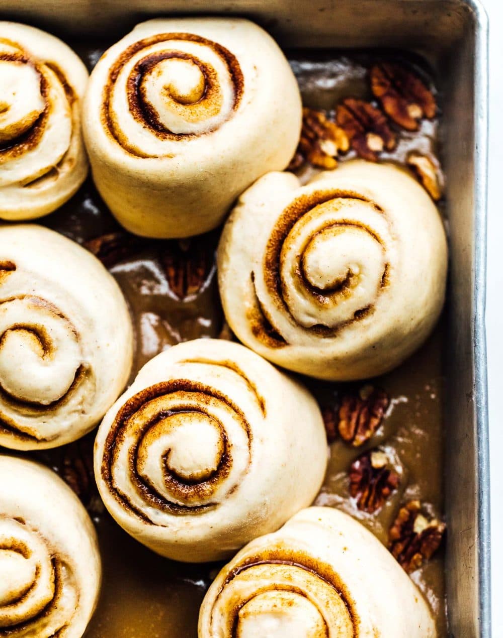 sourdough pecan buns after they are proofed, sitting in their caramel mixture.