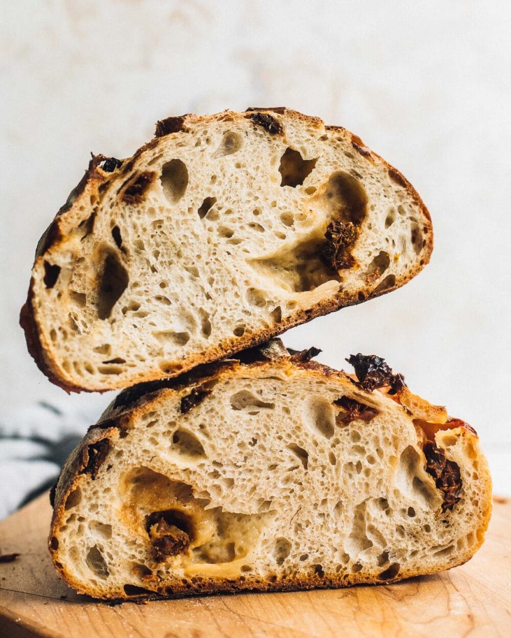 sundried tomato and cheddar sourdough, cut in half and halves stacked on top of each other, with crumb showing.