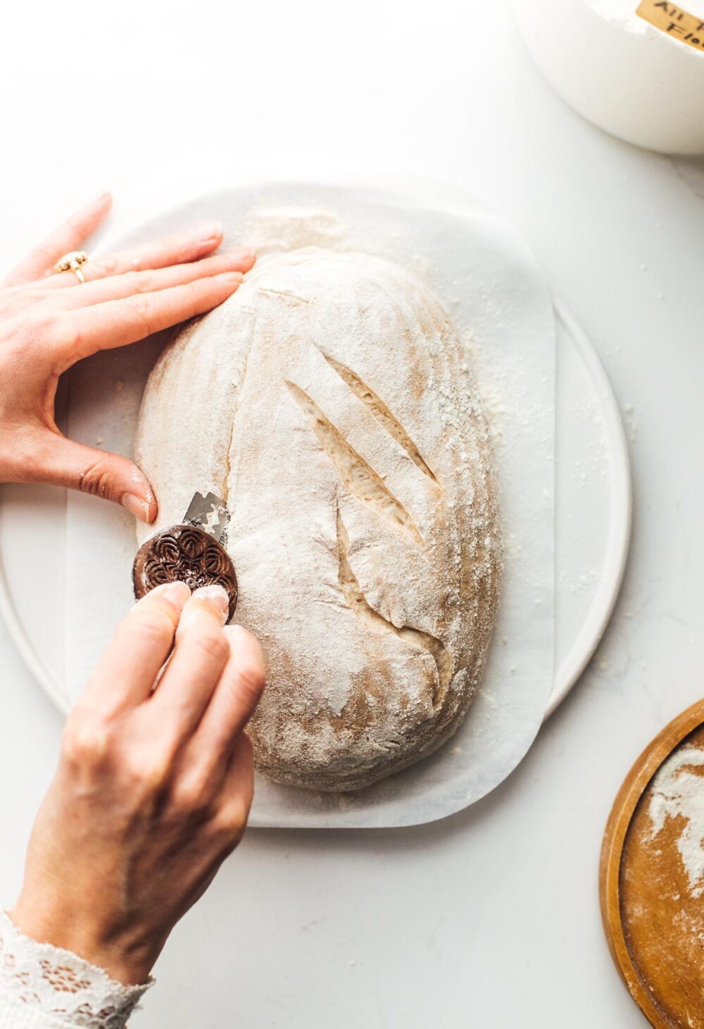 scoring sourdough bread on parchment paper