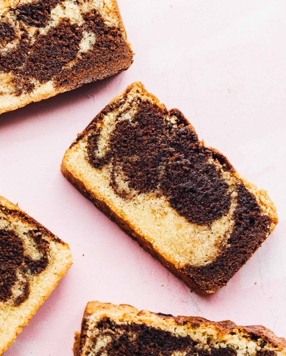 slices of gluten-free marble pound cake on pink background