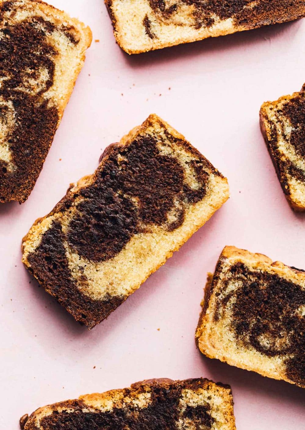 slices of marble pound cake on a pink backround