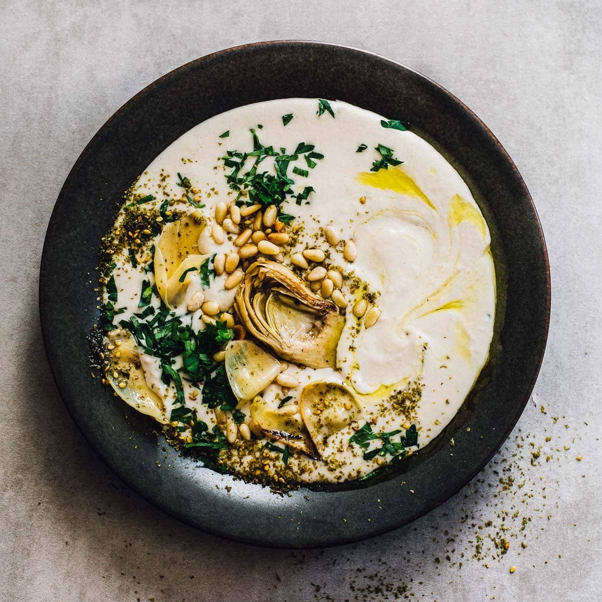 white bean hummus on a black plate