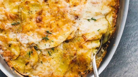 potatoes au gratin in a casserole with spoon