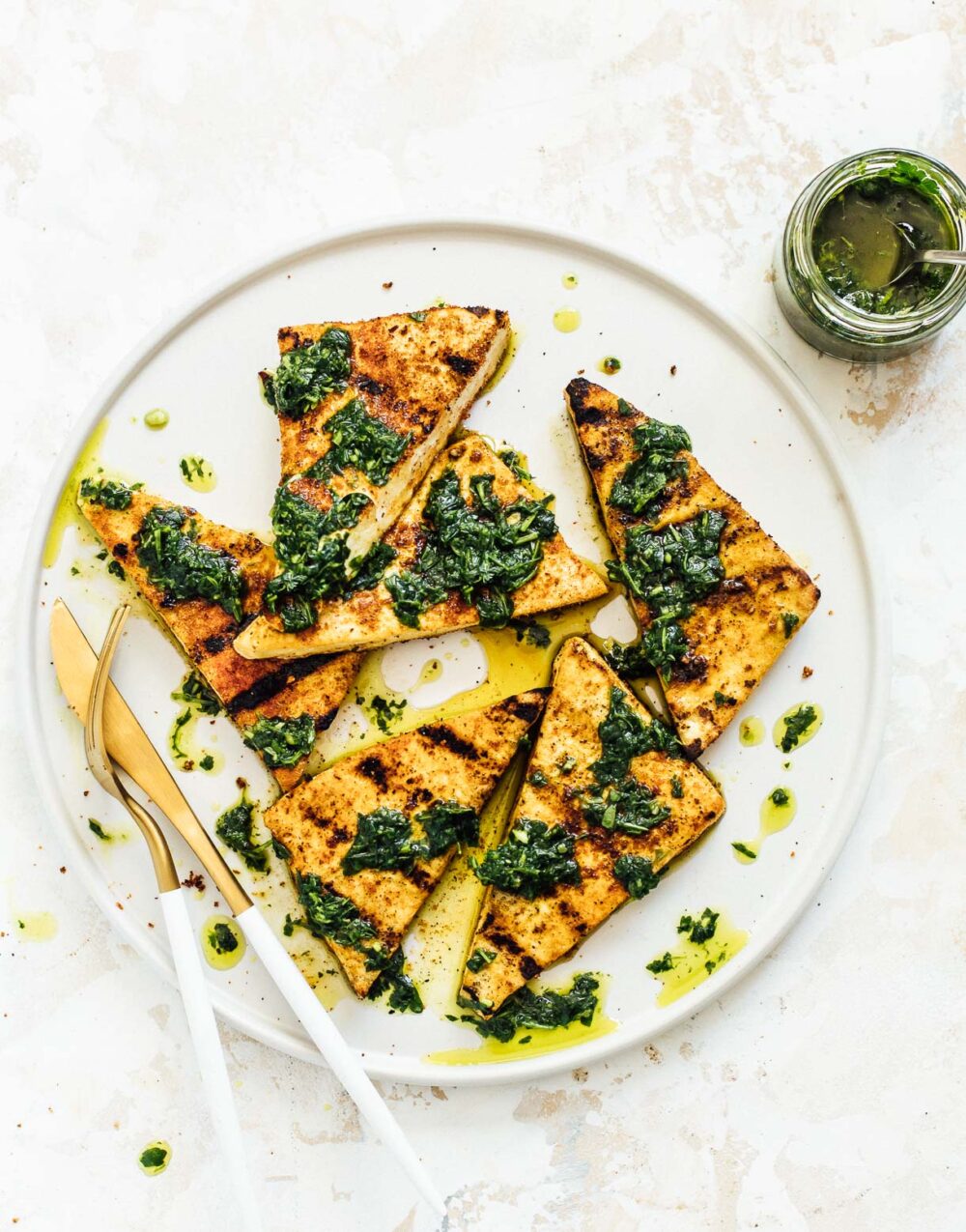 grilled tofu steaks with chimichurri on white plate