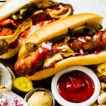 Grilled Brats in Buns with ketchup and mustard nearby